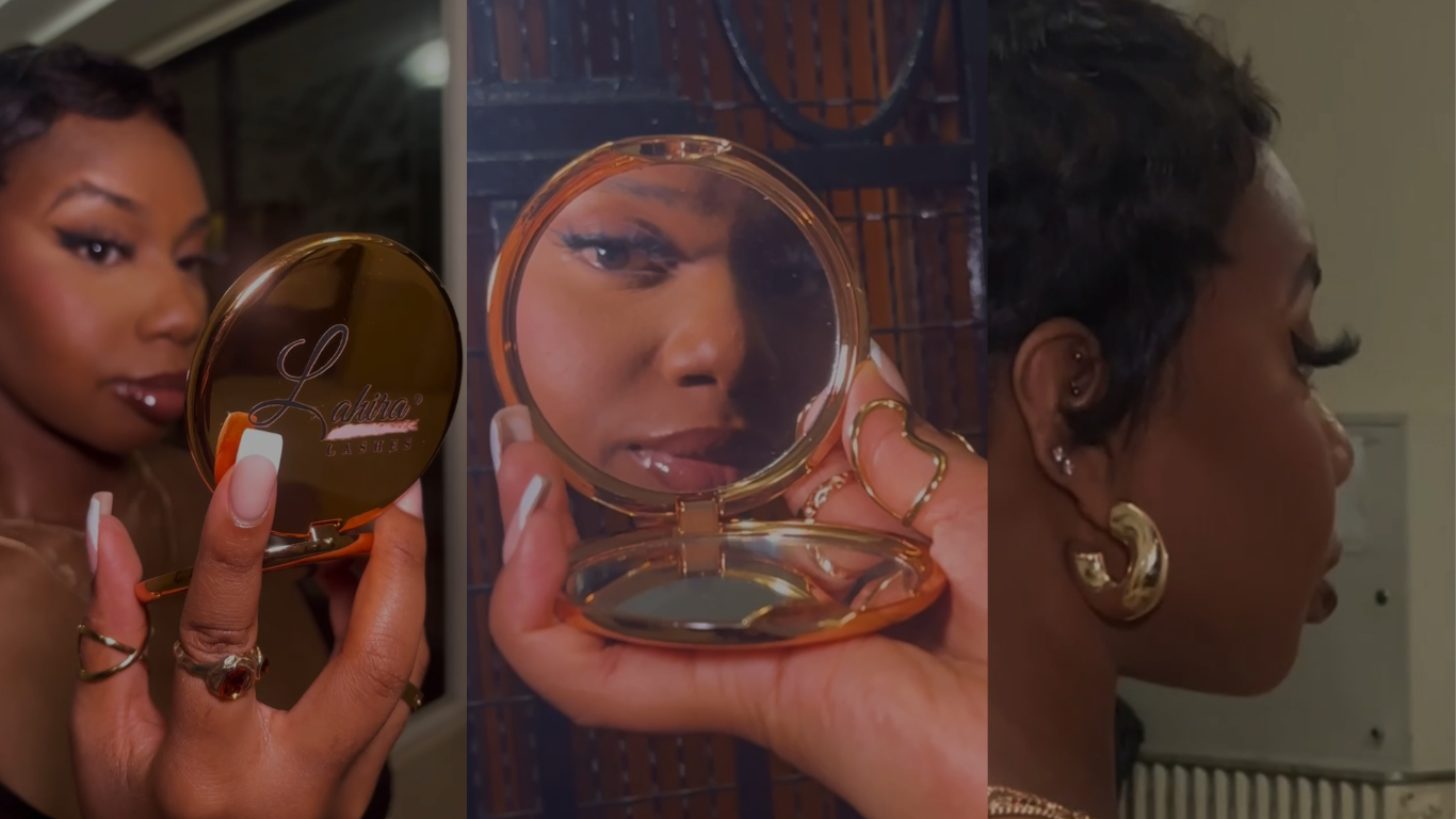 A woman wearing makeup and holding a compact mirror admiring at her false lashes